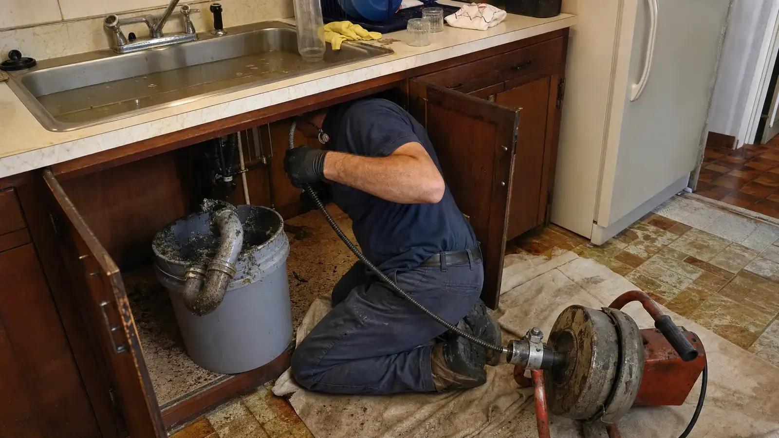 Clogged drain repair in a Denver kitchen with the P-trap removed and grease buildup visible