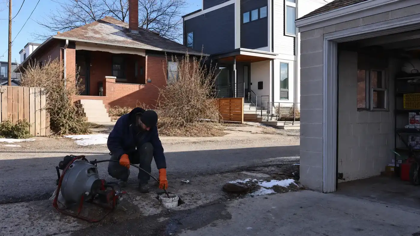 Drain cleaning service at a Highlands home in Denver next to new infill construction