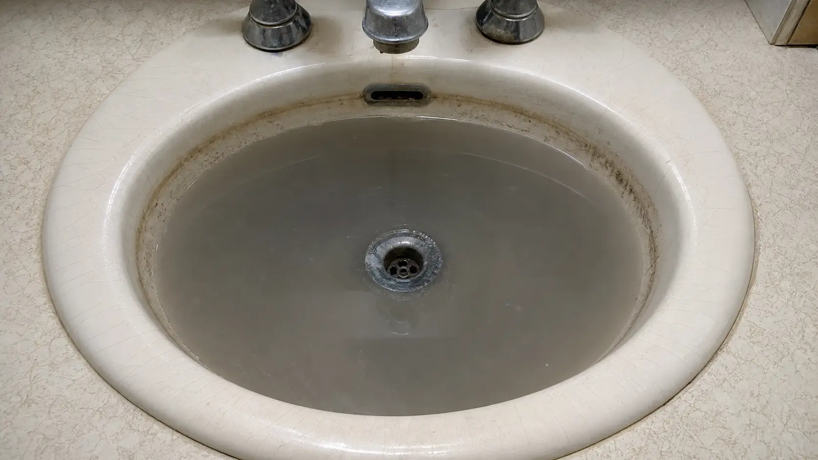 Slow draining bathroom sink with standing water, an early sign a Denver home needs drain cleaning